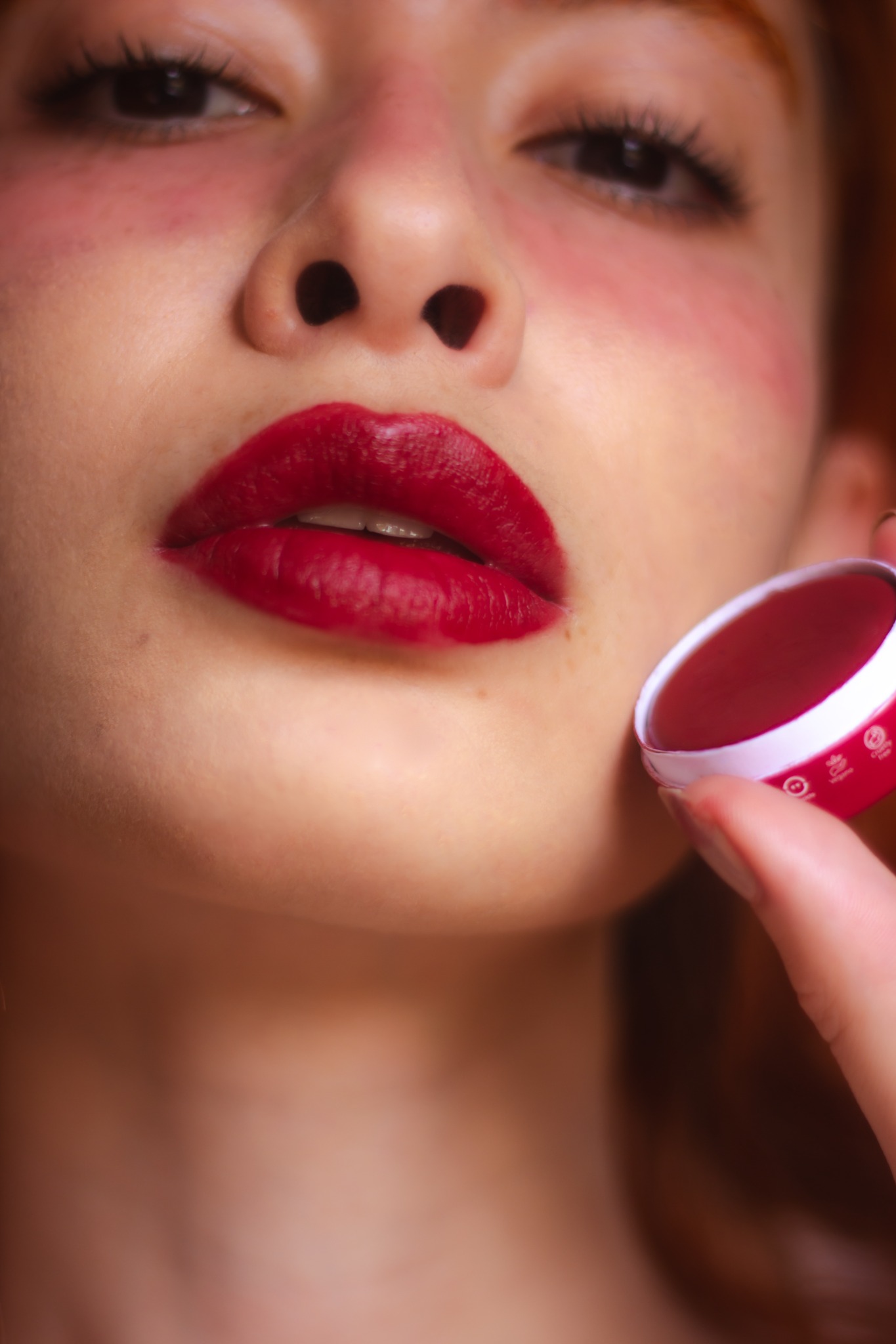 Modelo com balm vermelho Tekohá nos lábios